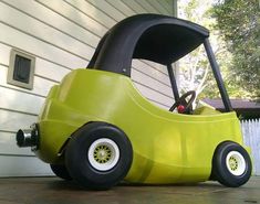 a small green car sitting on top of a driveway