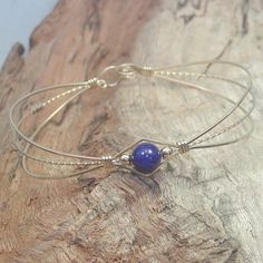 A sweet design of three strands of 14kt gold filled wire featuring a single 6mm genuine lapis bead flanked by two small 14kt gold filled beads. So delicate and feminine! It's likely that you have several blue outfits in your closet. Blue is the most cited favorite color of all! This stylish, well-fitting bangle will go with them all, and is sure to get noticed every time you wear it! The sturdy built-in hook and eye clasp is easy to get on and off by yourself. Choose your perfect size from the v Hand Wrapped Bangle Jewelry As Gift, Hand Wrapped Bangle Jewelry For Gifts, Hand Wrapped Bracelet Jewelry Gift, Elegant Adjustable Wrap Bracelet For Gift, Elegant Adjustable Wrap Bracelet Gift, Hand-strung Friendship Bracelet Jewelry, Hand-strung Friendship Bracelet, Elegant Friendship Wrap Bracelet, Delicate Adjustable Bangle Bracelet