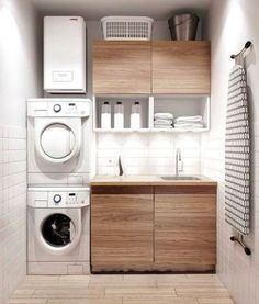 a washer, dryer and cabinets in a small room with tile flooring