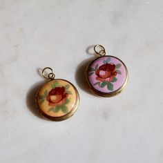 Vintage Yellow or Purple Round Locket Charm This round functioning locket charm features a vintage rose enamel cabochon estimated to have been produced in Japan in the 1950s. The locket is 20mm wide/tall and about 5mm thick. The locket base is made of raw brass and has a loop at the top for threading on a delicate chain or use in other jewelry creation. Vintage Pink Jewelry For Keepsake, Vintage Pink Keepsake Jewelry, Vintage Rose Design Pendant Jewelry, Vintage Enamel Jewelry With Vintage Charm, Vintage Enamel Collectible Jewelry, Vintage Enamel Jewelry For Collectors, Vintage Medallion Jewelry With Flower Charm, Vintage Rose Gold Jewelry With Flower Charm, Vintage Charm Round Enamel Jewelry