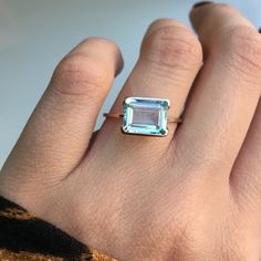 RING DETAILS: ✪Design: White gold solitaire ring ✪Gemstone: Natural aquamarine ✪Gemstone color: Blue ✪Gemstone shape: Emerald cut ✪Gemstone transparency: Transparent ✪Gemstone size: 7mm*9mm ✪Gemstone weight: 2.00 ct ✪Setting type: Half bezel ✪Metal type: 14k white gold ✪Gold weight: 1.28 gm ✪Metal finish: Smooth shiny Choose your ring size from drop down menu and if you need any other preferred ring size please contact us. QUALITY OF MATERIALS: Metal: Most of our jewelry at JewelryMansion is mad Bezel Set Aquamarine Ring, 14k Gold Radiant Cut Gemstone Rings, Solitaire Gemstones For Anniversary In Fine Jewelry Style, Anniversary Solitaire Gemstone Fine Jewelry, Fine Jewelry Solitaire Gemstones For Anniversary, Emerald-cut Topaz Ring In 14k White Gold, Fine Jewelry Topaz Ring With Bezel Setting, Blue Topaz Emerald Cut Ring With Bezel Setting, Emerald Cut Blue Topaz Ring With Bezel Setting