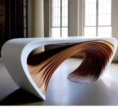 a large white table sitting in the middle of a room next to two tall windows