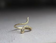 9k solid gold adjustable snake ring , made from recycled gold. Delicate and unique , The ring has been made in wax and then casted in 9k solid gold. Also available with Ruby gemstone : https://cyklu.etsy.com/listing/1575385029 MATERIAL- 9k gold Every piece you purchase from Cyklu is unique and handmade with love and affection, please allow one week after payment  ELSEWHERE - Instagram: instagram.com/CYKLU_JEWELRY -Pinterest: pinterest.com/Cyclu -Twitter: twitter.com/Cyklu - Facebook: Facebook.com/CykluJewelry Yellow Gold Brass Snake Ring As Gift, Yellow Gold Brass Snake Ring For Gift, Adjustable Yellow Gold Snake Ring, Adjustable Unique Yellow Gold Snake Ring, Adjustable 14k Gold Snake Ring, Dainty Gold Ring, Ring Wrap, Dainty Gold Rings, Snake Ring