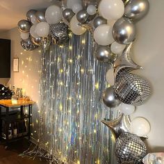 a room filled with lots of silver and white balloons