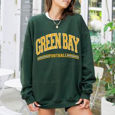 "Get ready for Green Bay football with this vintage-style, varsity sweatshirt. This crewneck has a retro design for your game day.  - These are Unisex fit. Please check sizing if you would like to order up 1-2 sizes for an oversized sweatshirt. * Packaged and Shipped in the USA! ---UNISEX SWEATSHIRTS--- - Specially spun cotton/poly, 50/50 - Medium-heavy soft fabric - Classic fit - Tear-away label - Runs true to size ---SIZES--- Small - 20\" W | 27\" L Medium - 22\" W | 28\" L Large - 24\" W | 29\" L XLarge - 26\" W | 30\" L 2XLarge - 28\" W | 31\" L 3XLarge - 30\" W | 32\" L 4XLarge - 32\" W | 33\" L ---CARE INSTRUCTIONS--- - Wash clothing inside out on cold setting - Tumble dry: low heat setting - Do not use bleach - Do not dry clean - Do not iron directly on design - Colors may look slig Oversized Tops For School Spirit In Fall, Oversized Tops For Fall With School Spirit, Varsity Long Sleeve Sweatshirt For Game Day, Fall Long Sleeve College Style T-shirt, Collegiate Sweater For Game Day, Collegiate Long Sleeve Sweater For Game Day, Team-colored Tops For Fall Streetwear, Green Varsity Long Sleeve Tops, Green Long Sleeve Varsity Top