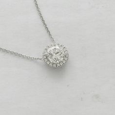 "Simple and elegant pendant made of 14K white gold. Features a 7mm, round Forever One Moissanite (1.20ct) surrounded by a halo of 20 diamonds,(0.15ct, G-VS quality) set in cut down micro pave style around the center stone. Measurements: 10mm. Price includes a 14K gold chain, 16 or 18\" long. Certificate of authenticity of moissanite is included with the ring. PROUDLY MADE FROM SCRATCH IN NEW YORK CITY. Please allow 2 weeks to complete this order. Document of authenticity of moissanite is include Dazzling Platinum Diamond Necklace With Halo Setting, Platinum Diamond Necklace With Halo Setting, Platinum Diamond Necklace With Halo Setting And Round Cut, Moissanite Diamond Necklace In White Gold With Halo Setting, Dazzling White Gold Solitaire Necklace With Halo Design, Platinum Diamond Necklace With Halo Setting In White Gold, White Gold Solitaire Halo Necklace For Formal Occasions, Formal White Gold Solitaire Necklace With Halo, White Gold Diamond Solitaire Necklace With Halo Design