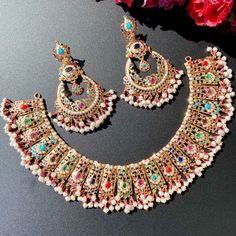 Featuring a bridal necklace set in gold, studded with navratna color stones. The necklace weighs 64.25 gms including 16.8 gms in the hanging beads. The chandbala earrings weigh 31.1 gms including 4.00 gms in the hanging beads. Watch Product Video Clip Price Breakup Summary Component Rupees % of Total 22k Gold 382,525 76.2% Stones & Beads 36,140 7.2% Making Charges 68,855 13.7% Taxes (GST) 14,626 2.9% Total 502,145 100.0% View Detailed Price Breakup Here Mehandi Jewellery, Jadau Necklace Set, 22k Gold Jewelry Necklaces, Jadau Necklace, Jadau Jewellery, Indian Bridal Jewelry Sets, 22k Gold Jewelry, Hanging Beads, Bridal Necklace Set