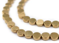 a long gold necklace is shown on a white background with space for an image to be used