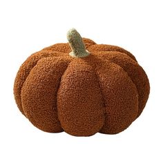 a pumpkin shaped pillow sitting on top of a white surface