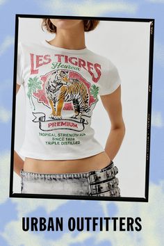 Baby tee with a Le Tigres printed at the front. Hits at the waist in a cropped silhouette with a crew neckline and cap sleeves. Find it exclusively at Urban Outfitters. Features Le Tigres graphic baby tee Tee with a Le Tigres graphic at the front Cropped silhouette Crew neckline UO exclusive Content + Care 100% Cotton Machine wash Imported Size + Fit Model in White is 5’10" and wearing size Small Measurements taken from size Small Chest: 24" Length: 17" | Le Tigres Baby Tee in White, Women's at Urban Outfitters Trendy Cropped T-shirt With Logo Print, Spring Short Sleeve Crop Top With Logo Print, Urban Outfitters Cotton Tops With Text Print, Fitted Cropped T-shirt With Logo Print And Crew Neck, Fitted Crew Neck Cropped T-shirt With Logo, Trendy Cropped Crew Neck T-shirt With Logo, Fitted Cotton Cropped T-shirt With Graphic Print, Cropped Graphic Tee With Logo Print, Fitted Crew Neck Crop Top With Logo Print