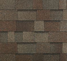 a close up view of a brown roof shingled with different shades of gray and tan