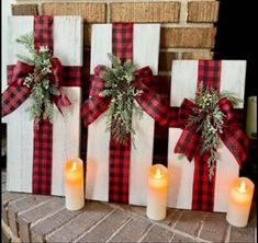 three wooden blocks decorated with plaid bows and candles are sitting next to each other on the brick