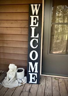 a welcome sign sitting on top of a wooden porch