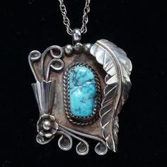 This is a Native American Navajo Shadowbox Turquoise Nugget Pendant Necklace Elaborate 925 Applique 19". This pendant necklace features a gorgeous turquoise nugget stone that is sawtooth bezel set in shadowbox with elaborate applique work that includes a long feather, raindrops, a cone with curled wire for flowers, more curled wire and a flower with raindrop center. Unsigned  Condition: Excellent vintage condition. Style: Pendant Necklace Metal: 925 Sterling Silver (tested) Surface: Polished Bail measures 3mm diameter Chain: Marked Sterling; measures 19" Measurement: 1 5/8" long; 1 3/8" wide Weight: 14.6 grams  Hallmark: A. Penketewa (Alan Penketewa) Tribal Affiliation: Navajo Native American #2641963 Southwestern Engraved Turquoise Necklace, Engraved Southwestern Turquoise Necklace, Collectible Turquoise Necklace With Natural Stones, Collectible Engraved Turquoise Necklace, Southwestern Style Engraved Turquoise Necklaces, Western Turquoise Pendant Necklace, Engraved Turquoise Necklace, Unique Engraved Turquoise Necklace, Southwestern Untreated Turquoise Necklace