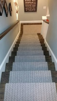 some stairs with pictures on the wall and carpeted flooring in front of them