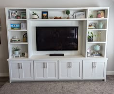 a white entertainment center with built - in shelving