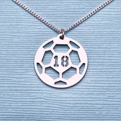 a soccer ball necklace with the number thirteen on it