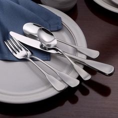 there are silverware on the plate with blue napkins