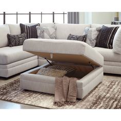 a living room scene with focus on the sectional sofa and footstool that is open