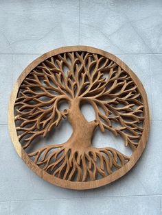 a circular wooden plaque with a tree on it