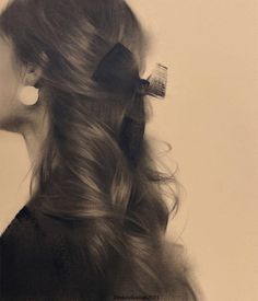 a black and white photo of a woman's hair with a bow in it