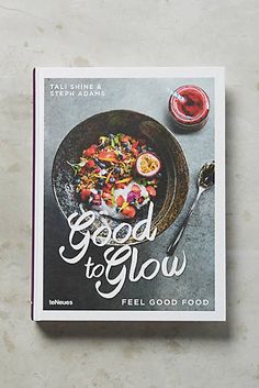 a cookbook with an image of food on the cover and spoon next to it