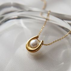 Featuring a stunning U-shaped pendant adorned with a lustrous pearl, the Ava Necklace adds a touch of elegance to any outfit. Treat yourself or a loved one to a beautiful and timeless accessory that will surely make a statement. -stainless steel, gold plated -15" with 2" extender Elegant Necklace With Pearl And Initial Pendant, Elegant Pearl Pendant Initial Necklace, Elegant Initial Pendant Necklace With Pearl, Elegant Pearl Jewelry With Initial Pendant, Elegant Pearl Initial Pendant Jewelry, Elegant Pearl Necklace With Initial Pendant And Pearl Charm, Elegant Pearl Necklace With Initial Pendant, Elegant White Pearl Necklace With Initial Pendant, Pearl Initial Pendant Necklace