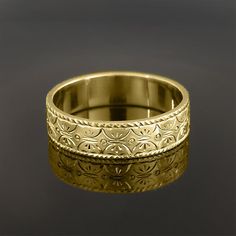 an intricately designed wedding band is shown on a black surface in this close up photo