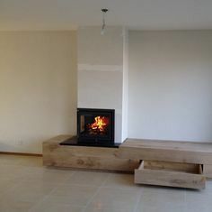 a wood burning stove in a room with white walls and tile flooring on the ground