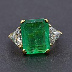 Absolutely stunning Colombian emerald mounted with 18k yellow gold  and platinum shank ! The 7.25CT emerald is from Colombia, beautiful rich green color and good clarity for its size. There are two sparkly trillion cut white diamonds adorning the center stone totaling 1.8 carat! I never understand the term "emerald garden" until I see this ring! The emerald has beautiful natural imperfections! This ring comes with one certification: Gemological Institute of America (GIA) Ring Size: 7 Total Weight: 6.16 grams Precious Metal: 18k yellow gold Precious stones: -Emerald Center Stone: 7.25 carats, 13.5mmx10.5mm -White Diamonds: 1.8 carat Hallmark: 18K Colombian Emeralds, Yellow Gold Rings, Diamond White, Precious Metals, Rings Statement, Precious Stones, Emerald, Statement Rings, Diamond Cuts