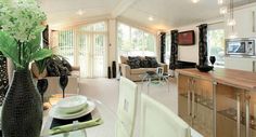 a living room filled with furniture next to a kitchen and dining room table in front of a window