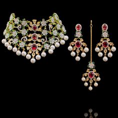 This set is not only beautiful for any wedding occasion but is a timeless piece of art! Stunning and classy set adorned with kundan stones and glistering ruby, emerald and CZ stones. Approximate earrings length is 3". This set is available in 2 options: Necklace + Earrings Necklace + Earrings + Teekah Please select the desired option at the time of purchase. Gold-plated on high-quality brass as base metal. Naleen Set (Without Teekah) is in-stock & ready-to-ship. Delivery time frame for the Nalee Kundan Sets For Formal Occasions In Temple Jewelry Style, Elegant Kundan Hand Set, Traditional Formal Sets With Stone Work, Wedding Kundan Necklace With Meenakari And American Diamond, Elegant Kundan Necklace With Ruby For Reception, Temple Jewelry Sets With Stone Work For Formal Occasions, Wedding Kundan Necklace With American Diamond, Kundan Necklace With American Diamond Stone Work For Weddings, Festive Formal Bridal Sets With Stone Work