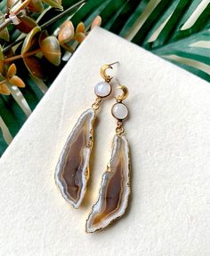 "\"Rúnar\" Exquisite honey brown 24k gold edged agate slices featuring luminous moonstone connectors, and gold moon earring posts. 3\" Long Nickel and Lead-Free Gold-plated Earring Hooks Brown Agate Earrings, Moonstone Earrings, Gold Moon Earrings, Brown Statement Earrings, Gold Crescent Moon Earrings, Light Brown Earrings, Unique Boho Earrings" Gold Earrings With Natural Agate Stones, Brown Brass Dangle Earrings, Gold Agate Earrings, Gold Agate Earrings With Natural Stones, Brown Brass Drop Earrings, Gold Agate Gemstone Earrings, Handmade Gold Earrings With Chalcedony, Earthy Brown Dangle Earrings, The Weeknd Concert Outfit