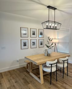 a dining room table with chairs and pictures on the wall