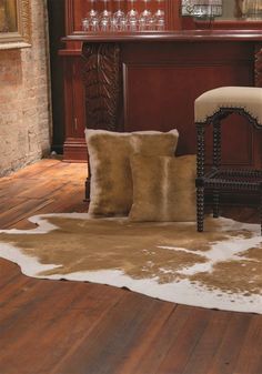 a chair sitting on top of a wooden floor next to a wine glass holder and table