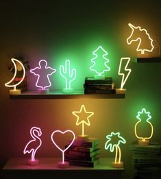 several neon signs are lit up on the wall next to books and other items in front of them