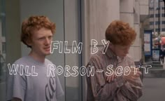 two young men standing next to each other in front of a glass wall with the words film by will robinson scott