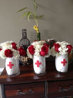 three vases filled with flowers on top of a wooden table