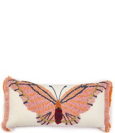 an embroidered butterfly pillow with fringes on the front and back, sitting on a white surface