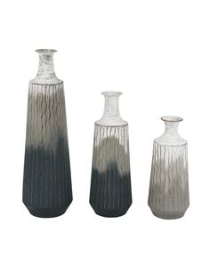 three vases sitting next to each other on a white surface