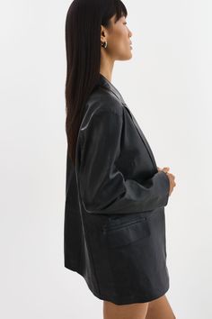 Indulge in the timeless elegance of the QUIRINA Leather Blazer, a quintessential addition to every discerning wardrobe. Crafted with a peaked lapel design and adorned with classic flap pockets, this blazer exudes sophistication and versatility. Its unlined construction ensures a feather-light feel, ideal for navigating transitional seasons with ease. Pair it effortlessly with jeans and a tee for an understated yet chic ensemble, or channel refined professionalism with the YAREN Leather Pants and Lapel Design, Feather Light, Black Xs, Leather Blazer, Classic Flap, Black Blazers, Skirt Pants, Flap Pocket, Dress Accessories