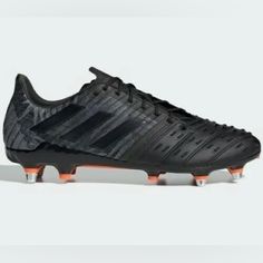 the adidas soccer shoe is shown in black and grey colors, with an orange sole