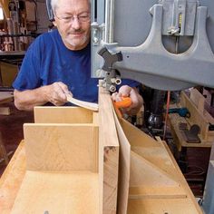 a man is working on some wooden drawers