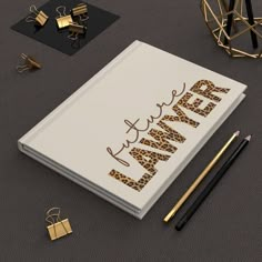 an open notebook with the word planner written on it next to some gold and black items