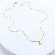 This tiny wishbone gold charm necklace is perfect for adding a touch of luck and charm to any outfit, making it an ideal gift for friends and family. Material: * 18k gold plated over sterling silver vermeil wishbone charm * Gold plated dainty cable chain Size: * Wishbone size: 10mm x 6mm * 18" chain length Dainty Gold Plated Initial Necklace, Dainty Gold-plated Initial Necklace, Minimalist Tiny Charm Necklaces In Gold Plated, Minimalist Tiny Gold Plated Charm Necklaces, Tiny Minimalist Gold Plated Charm Necklaces, Minimalist 16-inch Charm Necklace For Gift, Dainty Gold Brass Charm Necklace, Tiny Minimalist Gold-plated Charm Necklace, Minimalist 14k Gold-filled Pendant Charm Necklace