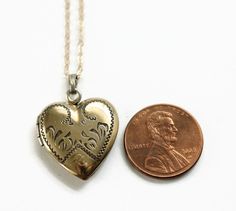 Vintage Heart Locket Necklace. This gold filled locket has decorative engravings and the letter P at the bottom. On the back, it is engraved with the date 8-19-5. Inside the locket contains one metal frame. The locket opens and closes easily and securely. The new gold filled chain was added by me, not vintage. Circa 1950's No hallmarks Measurements- Chain is 18 inches in length Locket is about 1 inch length Very good condition. Minor wear due to age and use. Vintage Heart Pendant Locket Jewelry, Victorian Locket Jewelry For Valentine's Day, Victorian Locket For Valentine's Day, Heirloom Locket Necklace With Vintage Charm For Anniversary, Heirloom Vintage Charm Locket Necklace For Anniversary, Vintage Yellow Gold Heart Jewelry, Heirloom Medallion Locket Necklace For Valentine's Day, Valentine's Day Engraved Medallion Jewelry, Valentine's Day Heirloom Medallion Locket Necklace