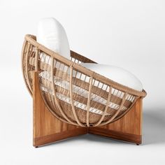 a chair made out of wicker and wood with white pillows on the backrest