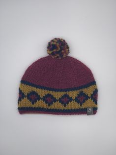 a knitted hat with a pom - pom on the front and side