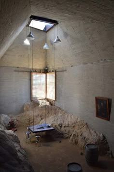 a room that has some lights hanging from the ceiling and rocks in front of it