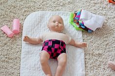 a baby doll laying on top of a towel